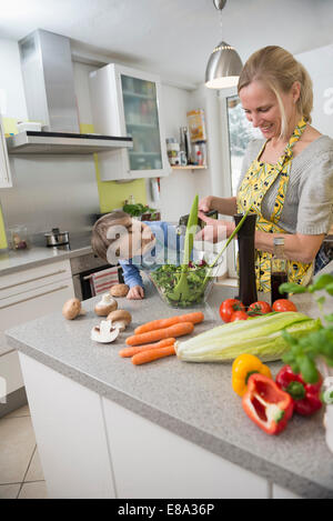 Junge seine Mutter beobachten, während sie Salat, Aromen lächelnd Stockfoto