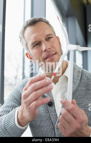 Geschäftsmann, der Windkraftanlage aussieht Stockfoto