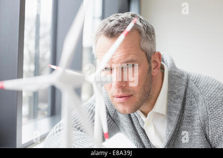 Geschäftsmann, der Windkraftanlage aussieht Stockfoto