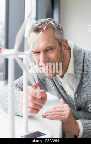 Geschäftsmann, der Windkraftanlage aussieht Stockfoto