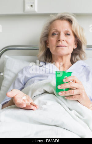 Patienten im Krankenhaus holding Cup und Pillen Stockfoto