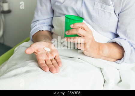 Patienten im Krankenhaus holding Cup und Pillen Stockfoto