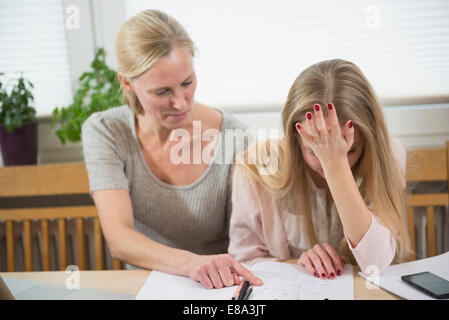 Mutter Tochter zu helfen, bei den Hausaufgaben, Lächeln Stockfoto