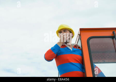 Bauarbeiter auf der Baustelle mit Bagger Stockfoto