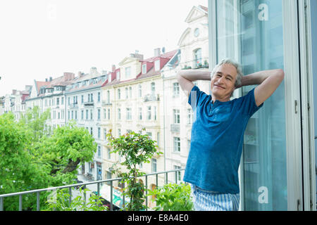 Porträt von reifer Mann stehend auf Balkon, Lächeln Stockfoto