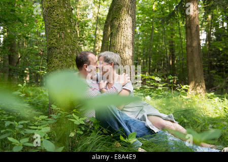 Älteres Paar küssen im Wald Stockfoto