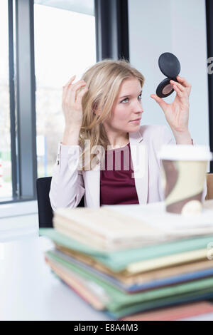 Geschäftsfrau, die in den Spiegel schaut Stockfoto