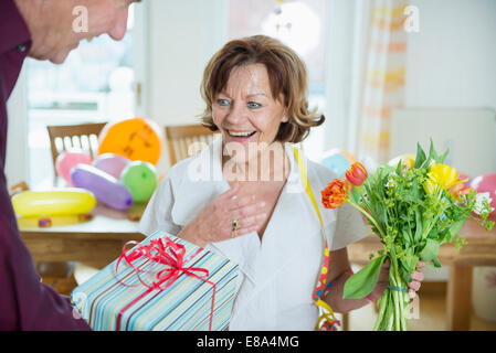 Senior Woman Hand über Geschenk an Frau zum Geburtstag, Lächeln Stockfoto