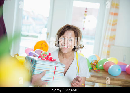 Senior Woman Hand über Geschenk an Frau zum Geburtstag, Lächeln Stockfoto