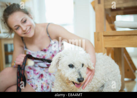 Mädchen mit ihrem Hund im lebenden Raum, lächelnd Stockfoto