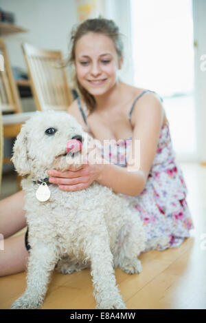 Mädchen mit ihrem Hund im lebenden Raum, lächelnd Stockfoto