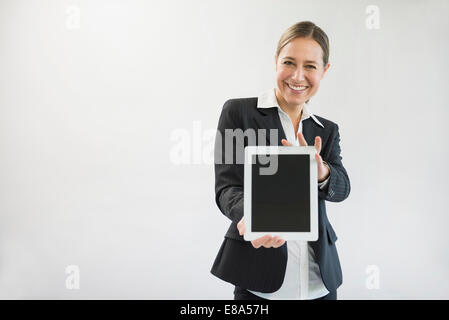 Porträt der Geschäftsfrau im schwarzen Anzug Holding digital-Tablette, Lächeln Stockfoto