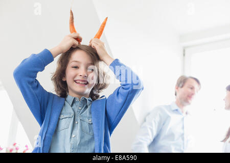 Porträt von Mädchen, Teufel mit Karotten als Hörner, Lächeln Stockfoto