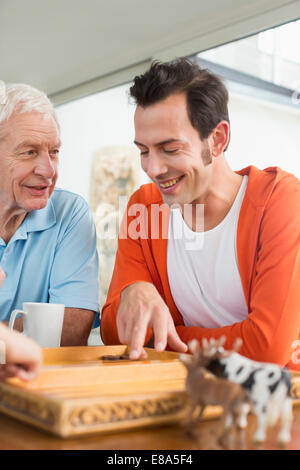 Vater und erwachsener Sohn spielen backgammon Stockfoto