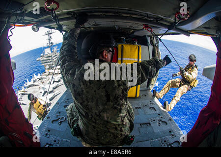 US-Segler, die Explosive Ordnance Mobile Abfallbehälter 5 zugewiesen führen eine Hubschrauber Seil Aussetzung Technik Übung auf dem Flugzeugträger USS George Washington (CVN-73) in der Philippinensee 9. September 2014. Stockfoto