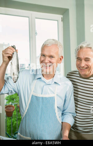 Reife Männer präsentieren Forellen Fischen, Lächeln Stockfoto