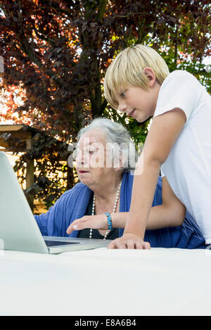 Oma und ihr Enkel Blick auf laptop Stockfoto