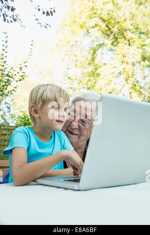 Oma und ihr Enkel mit laptop Stockfoto