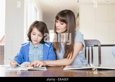 Mutter Tochter in Hausaufgaben, helfen lächelnd Stockfoto
