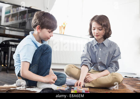 Mädchen und Jungen spielen Brettspiel Stockfoto