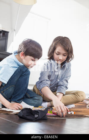 Mädchen und Jungen spielen Brettspiel Stockfoto