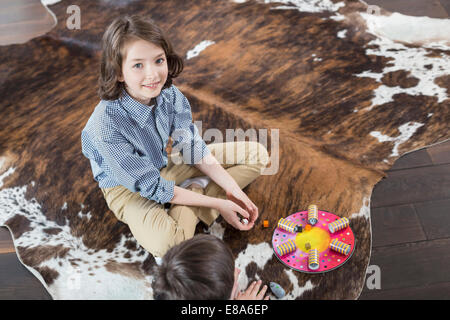 Mädchen und Jungen spielen Brettspiel Stockfoto