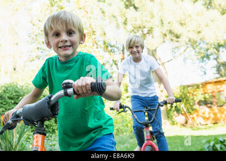 Zwei Brüder mit ihren Fahrrädern im Garten Stockfoto