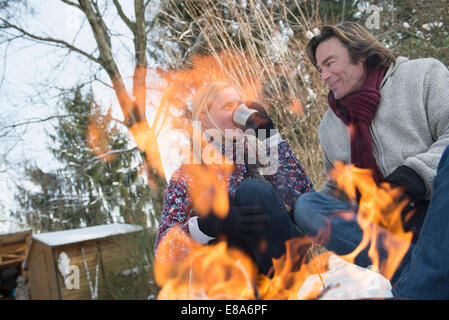 Paar beim Feuer saß und warmen Getränk, Bayern, Deutschland Stockfoto