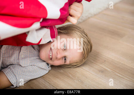 Junge versteckt unter Bett Stockfoto