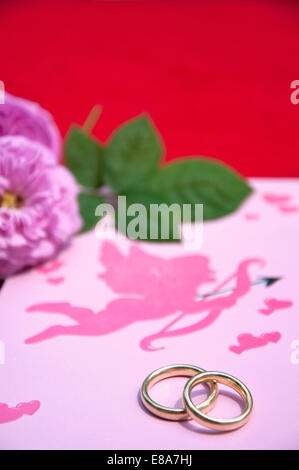 Eheringe auf Hochzeitskarte mit Rosen, Nahaufnahme Stockfoto