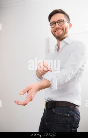 Junger Geschäftsmann aufrollen Hemd Ärmel Porträt Stockfoto