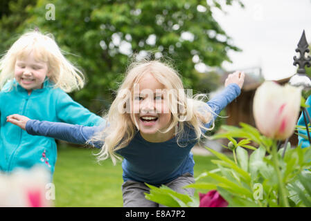 Zwei Blonde Kinder Schwestern spielen im Garten Stockfoto