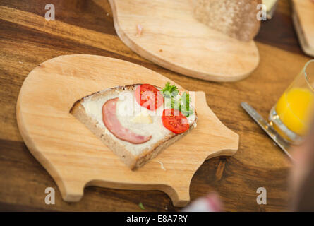 Stück Brot und Butter geformt wie ein lächelndes Gesicht Stockfoto