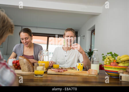 Junge Familie sitzen gesund frühstücken Stockfoto