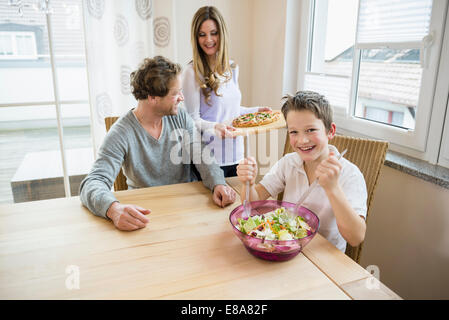 Familie zu Hause essen Pizza und Salat Stockfoto