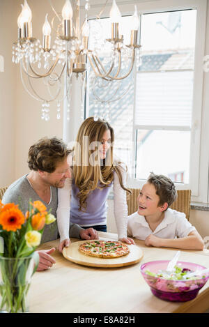 Familie zu Hause essen Pizza und Salat Stockfoto