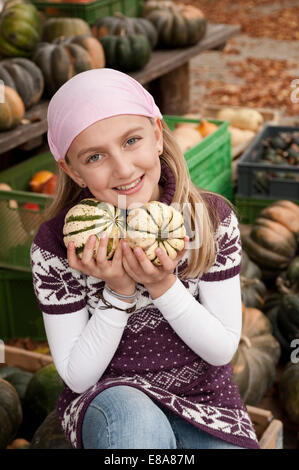 Lächelndes Mädchen hält Kürbisse Stockfoto