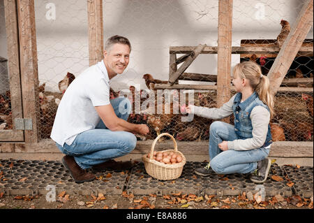 Vater und Tochter im Hühnerstall auf Bio-Bauernhof Stockfoto