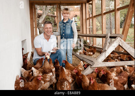 Vater und Tochter im Hühnerstall auf Bio-Bauernhof Stockfoto