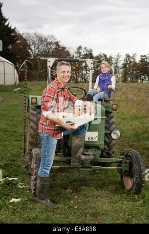 Bauer mit Tochter auf Traktor Stockfoto