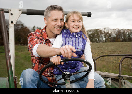 Bauer mit Tochter auf Traktor Stockfoto