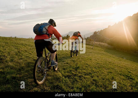 zwei Mountainbiker auf dem Weg bei Sonnenuntergang, Kolovrat, Istrien, Slowenien Stockfoto