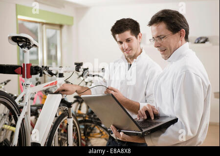 Mechanik, Elektro-Fahrrad mit Laptop testen Stockfoto