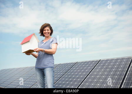 Frau mit kleinen Modell Haus Solarenergie Stockfoto