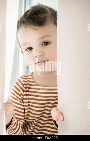 Porträt eines jungen spielen mit Vorhang Stockfoto