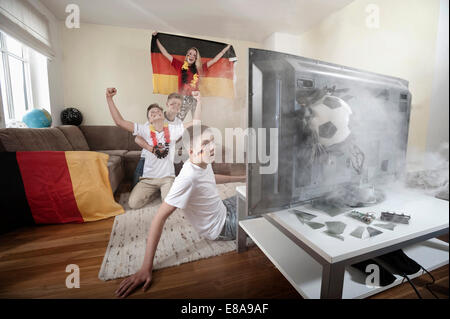 Teenager Fußballfans im Wohnzimmer mit Ball Abriss TV Stockfoto