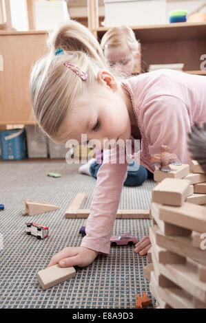 Kleine Mädchen spielen mit Holz Bausteine in ihrem kindergarten Stockfoto