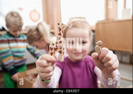 Kleines Mädchen mit Holzspielzeug in ihrem kindergarten Stockfoto