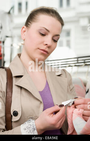 Junge Frau sucht Preisschild Stockfoto