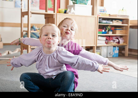 Porträt von zwei kleine Schwestern im Kindergarten Zungen herausragen Stockfoto